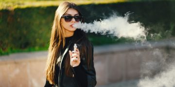 stylish girl smoking an e-cigarette
